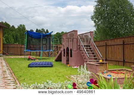 A children slide, trampoline and sandbox on the playground in the country house