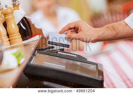 Close-up billede af kassereren mandlige hænder holder kortet