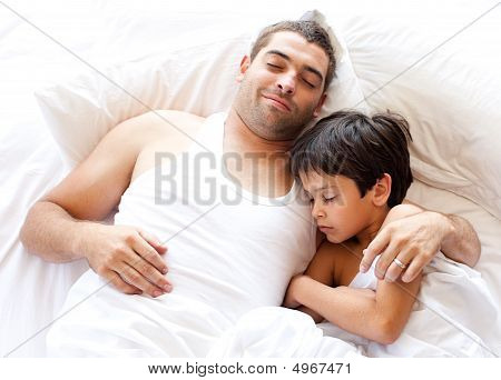 Vater und Sone schlafend auf dem Bett
