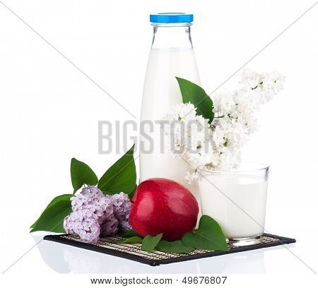 Bottle of milk with branch lilac and red apple, isolated on white background 
