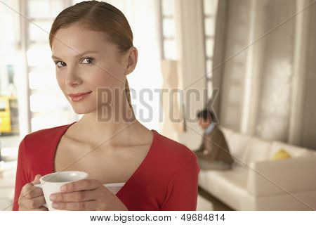 Portrait of confident businesswoman holding coffee cup in office lobby