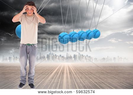 Embarressed brunette man against newtons cradle above city