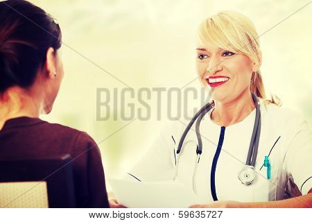 Mature female doctor talking with her patient. 