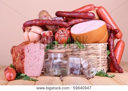 Lot of different sausages on wooden table on beige background