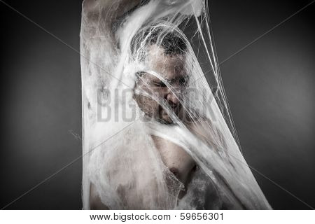 Danger. man tangled in huge white spider web