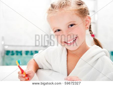 Little girl brushing teeth in bath