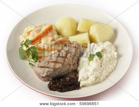 Veal sirloin steak with onion marmalade, celeriac puree, julienned carrots in a white sauce and boiled potatoes, garnished with parsley.