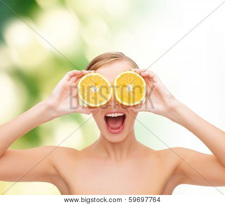 health, nutrition and beauty concept - clean face of beautiful young woman with orange slices
