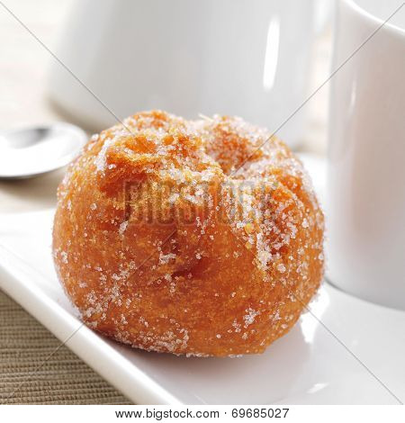 closeup of a bunuelo de viento, a typical pastry of Spain, eaten in Lent, served on a plate and a cup of coffee