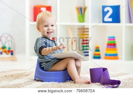 smiling child sitting on chamber pot indoor