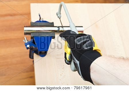 Plumber Sawing Plumbing Drain Pipe Gripped In Vice