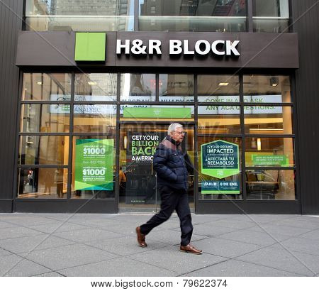 NEW YORK CITY - MONDAY, DEC. 29, 2014: Pedestrians walk past an office of H&R Block. H&R Block is a tax preparation company in the United States