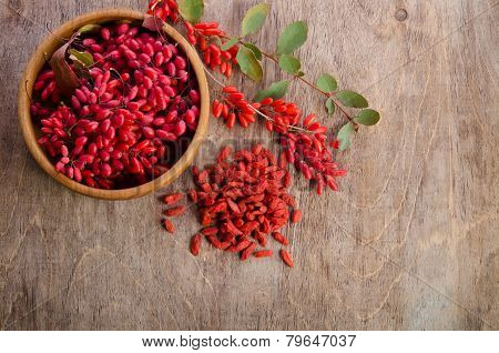 Barberry With Leaves And Dry Goji Berries On Wooden Background
