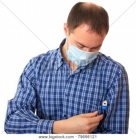 Man in a medical mask with a thermometer.