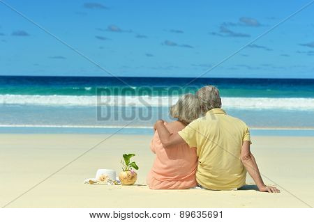 Elderly couple sitting on the shore