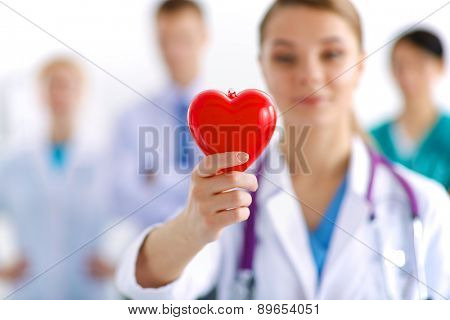 Female doctor with stethoscope holding heart.