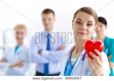 Female doctor with stethoscope holding heart.