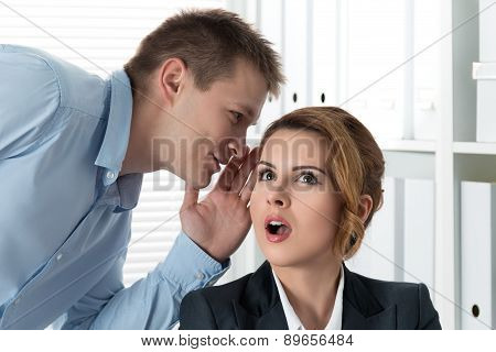 Young Man Telling Gossips To His Woman Colleague