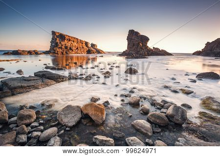 Dramatic Sunrise With Mist On The Beach With Rocks