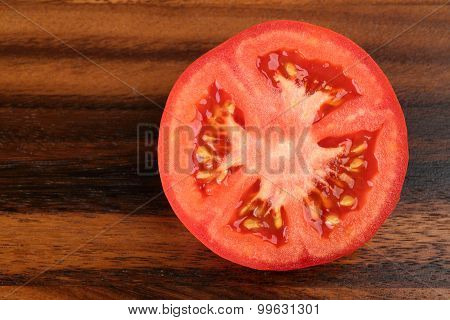 Top View Of Half Tomato On Wooden Background. Sliced Tomato