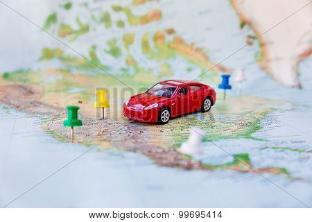 Road Trip - Car Goes On Map Across The Territory Of The Usa. The Route Of Automobile Travel.