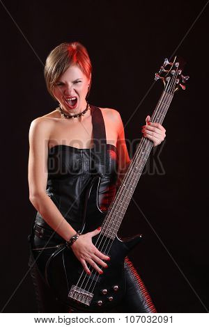 Sexy girl in leather clothes with bass guitar