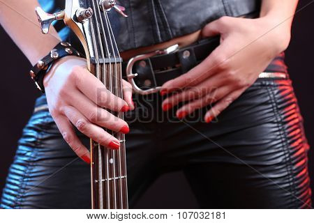 Sexy girl in leather clothes with bass guitar