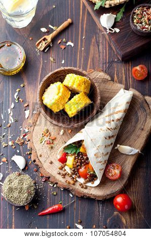 Vegan tortilla wrap, roll with grilled vegetabes, lentil, corn cob.