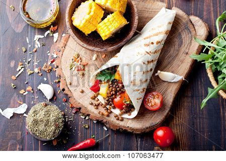 Vegan tortilla wrap, roll with grilled vegetabes, lentil, corn cob.