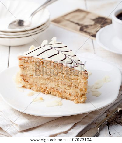 Traditional Hungarian Esterhazy cake with coffee cup and vintage postcards .