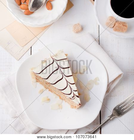 Traditional Hungarian Esterhazy cake with coffee cup and vintage postcards .
