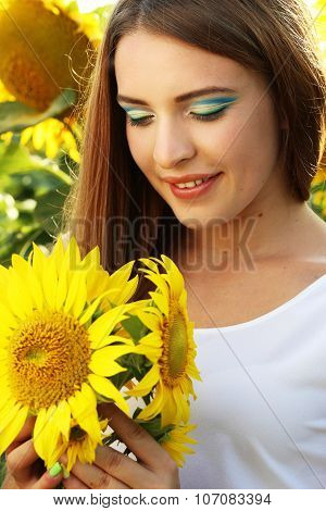Bea?tiful girl in the sunflowers field