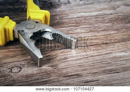 multitool pliers on wooden background