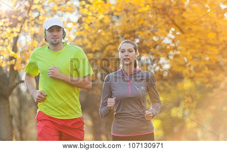Young couple running in autumn season. Concept of fitness exercise and bidy training