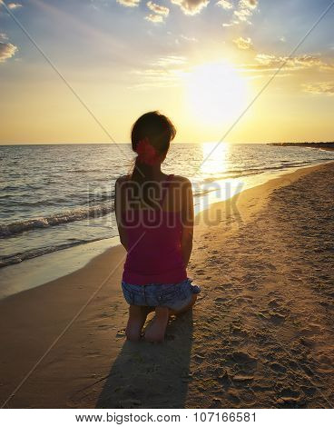 Girl Kneeling On The Beach