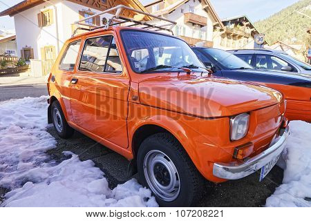 Shiny Red Car Parked In The Street Of A Charming Garmisch-partenkirchen
