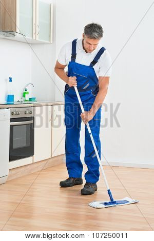 Worker Mopping Floor In Kitchen At Home