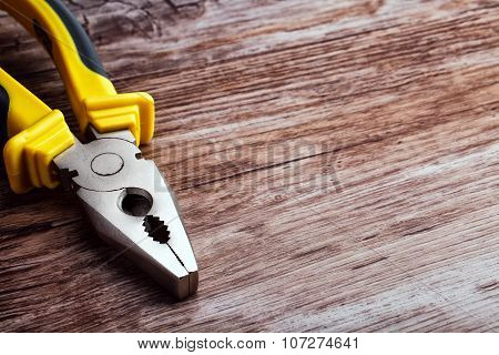 multitool pliers on wooden background