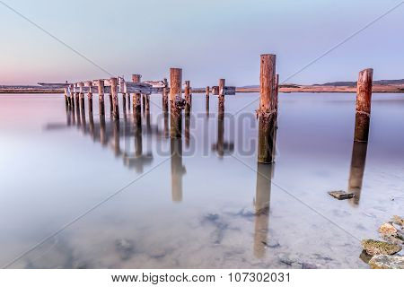 Old wooden pier at sunset broken in the river Barbate, Cadiz, Spain