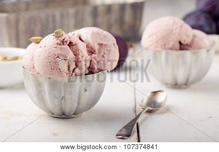 Plum ice cream with cardamon seeds. White background.