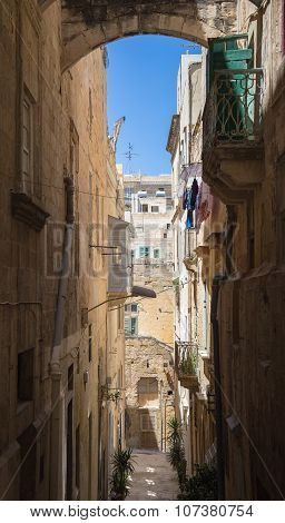Streetview of Valletta with arch and clear blue sky - Malta