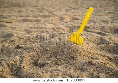 Children's yellow shovel on the beach