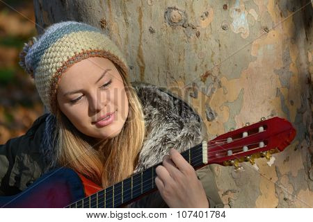 Girl With Woolen Cap And Guitar