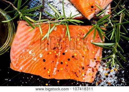 Portions Of Fresh Raw Salmon Fillets With Aromatic Herbs And Olive Oil