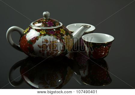 Chinese Jug And Two Cups With Mirrored Reflection On Isolateg Gray