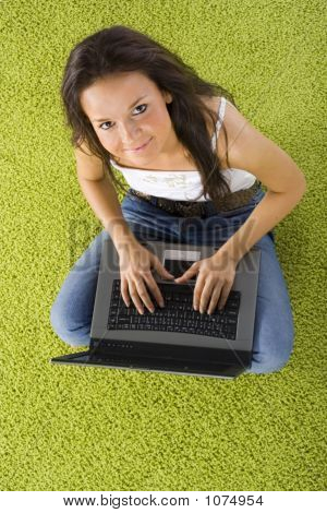 Jonge vrouw met Laptop op het groene tapijt