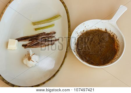 Pan Of Bagna Cauda With A Dish Of The Ingredients That Are Used To Cook