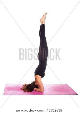 Beautiful woman doing Parsva Salamba Sirsasana pose on yoga class. Studio shot.