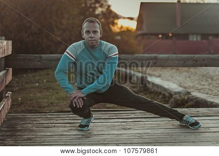 Sport Man Stretching Aoutdoors Doing Exercises Evening At Sunset. Fitness Concepts.