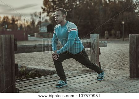 Sport Man Stretching Aoutdoors Doing Exercises Evening At Sunset. Fitness Concepts.